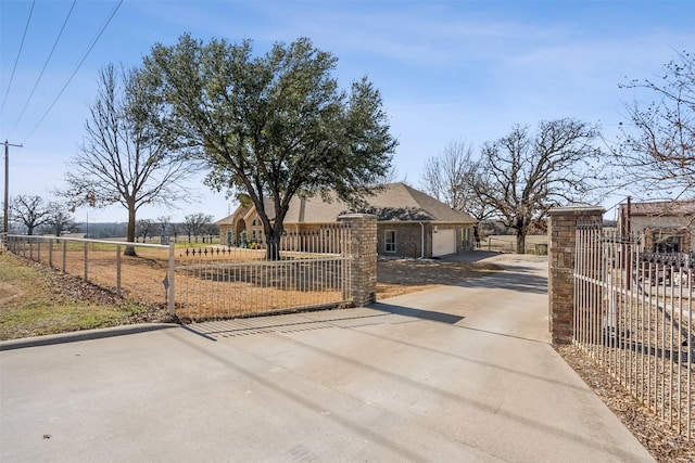 view of front of property featuring driveway, a fenced front yard, and an attached garage