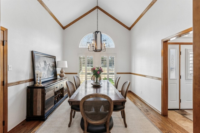 dining space featuring crown molding, wood finished floors, and a notable chandelier