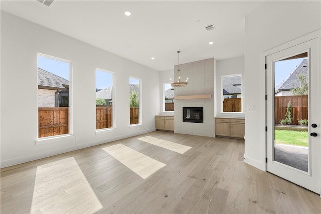 4201 Linear, Prosper, TX 75078 - unfurnished living room featuring light wood finished floors, a chandelier, recessed lighting, baseboards, and a large fireplace