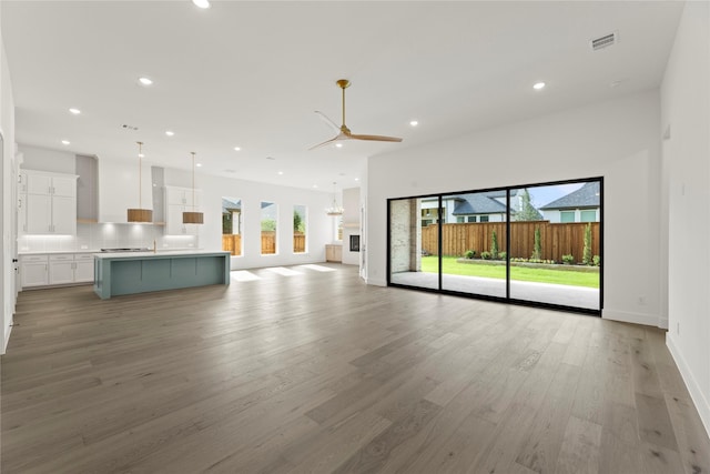 4201 Linear, Prosper, TX 75078 - unfurnished living room featuring a ceiling fan, recessed lighting, light wood-type flooring, baseboards, and a sink
