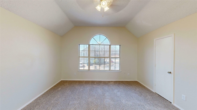 unfurnished room with baseboards, a ceiling fan, lofted ceiling, a textured ceiling, and carpet floors