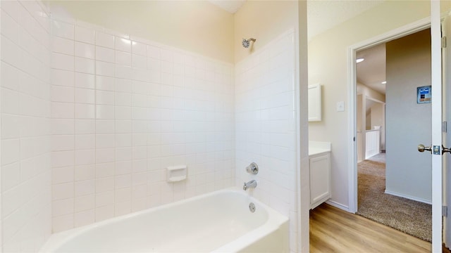 full bath featuring shower / bath combination, wood finished floors, vanity, and baseboards