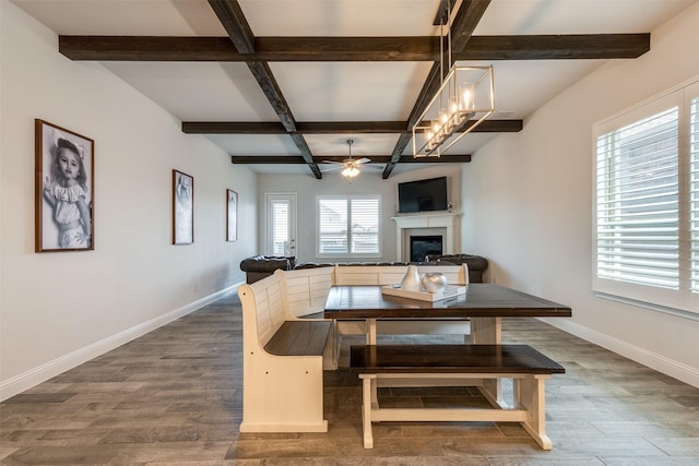 dining area featuring a fireplace, baseboards, and wood finished floors