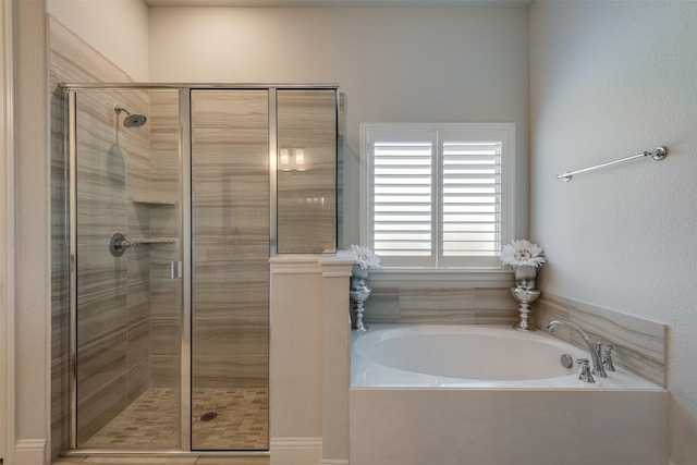 bathroom featuring a shower stall and a bath