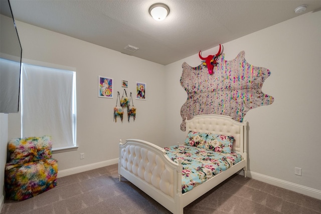 bedroom with carpet, a textured ceiling, visible vents, and baseboards