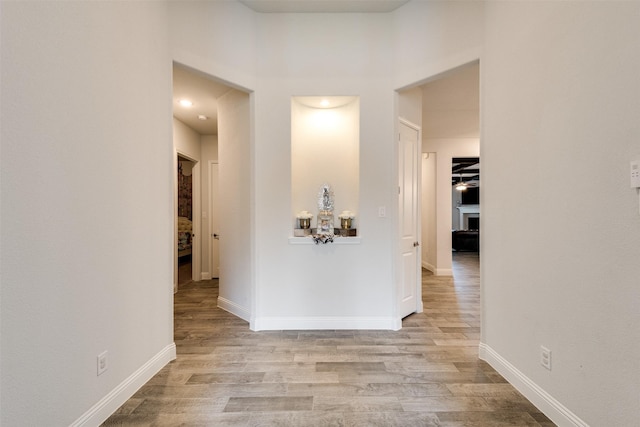 hallway with baseboards and wood finished floors