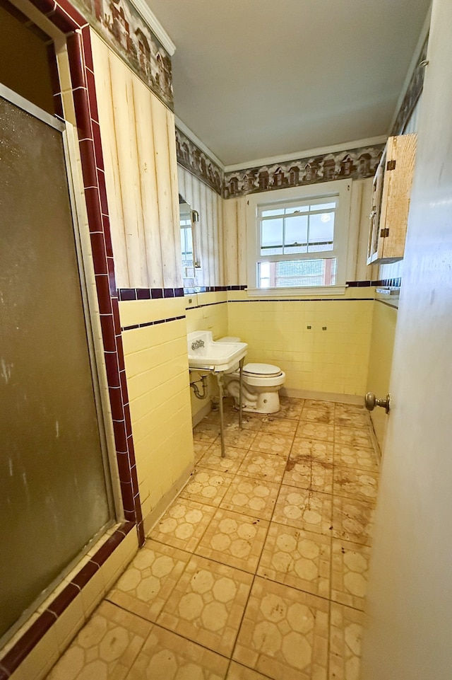 full bath with tile walls, a shower stall, and toilet