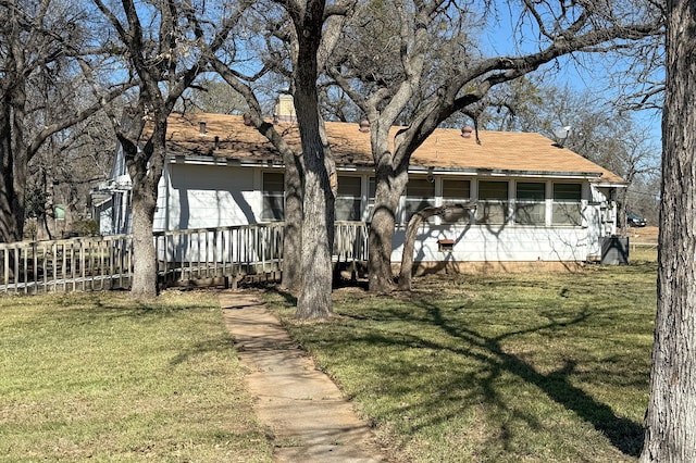 exterior space featuring a lawn and a chimney