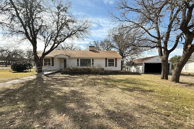 view of front of property featuring an outbuilding, a front lawn, and a chimney