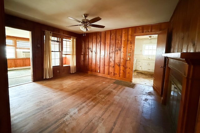 spare room with a ceiling fan, baseboard heating, hardwood / wood-style flooring, and a healthy amount of sunlight