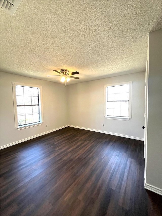 unfurnished room featuring a healthy amount of sunlight, baseboards, and dark wood finished floors