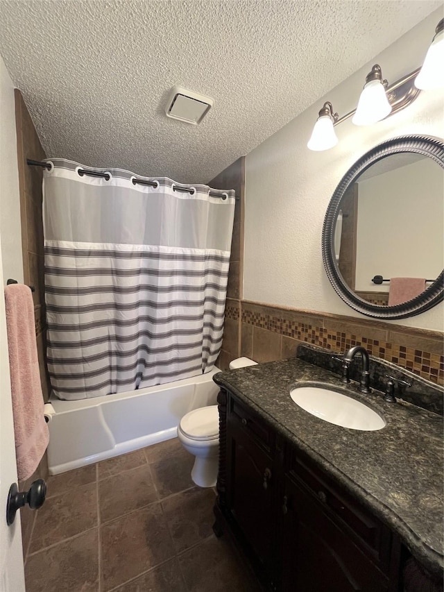 bathroom featuring a textured ceiling, toilet, tile walls, vanity, and shower / tub combo with curtain