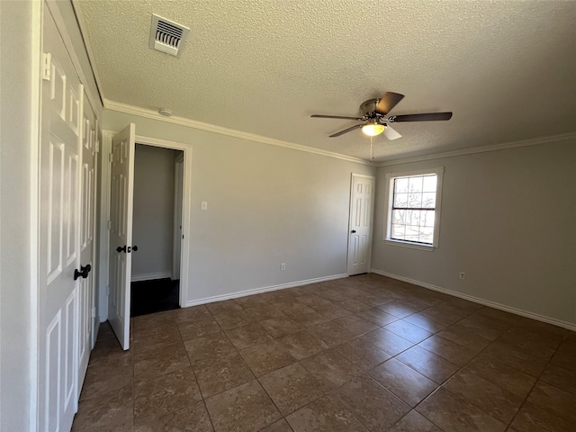 spare room featuring ornamental molding, visible vents, and baseboards