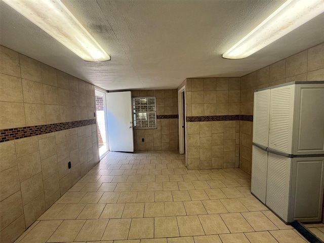 interior space featuring a textured ceiling and light tile patterned floors