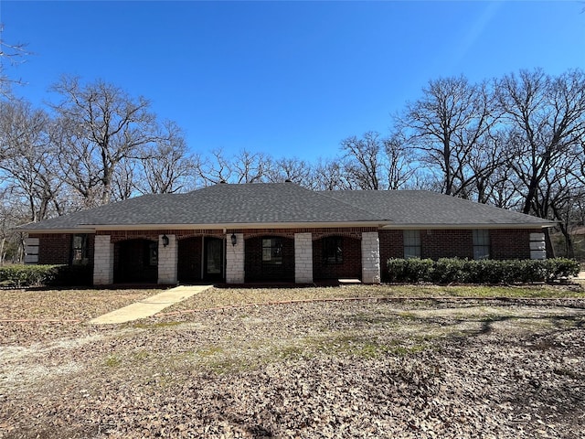 ranch-style house with a shingled roof and brick siding