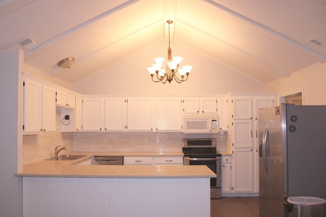 kitchen featuring appliances with stainless steel finishes, visible vents, a sink, and a peninsula