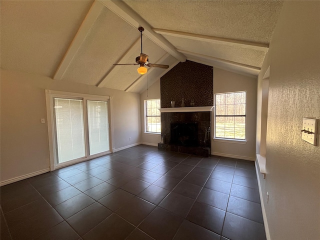 unfurnished living room with a fireplace, lofted ceiling with beams, ceiling fan, a textured ceiling, and baseboards