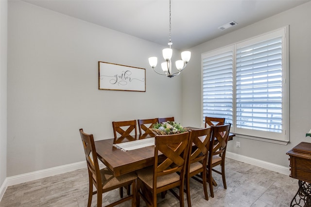 dining area with an inviting chandelier, baseboards, and visible vents