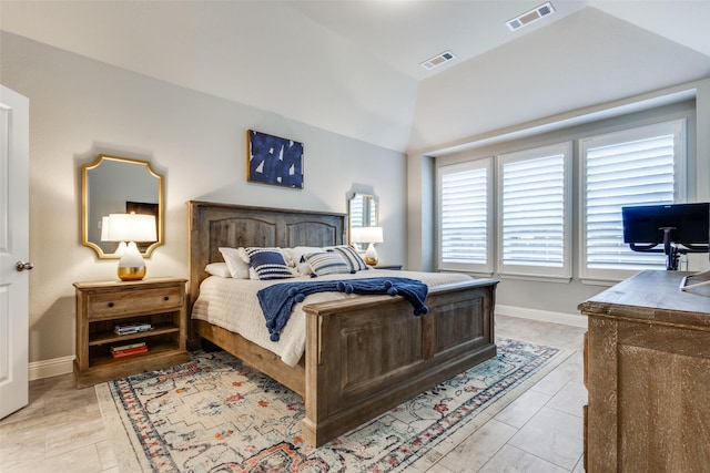 bedroom with vaulted ceiling, visible vents, and baseboards