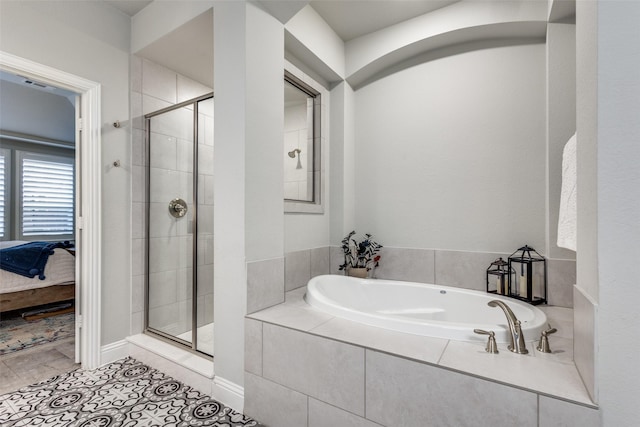 ensuite bathroom featuring ensuite bathroom, tile patterned flooring, a shower stall, and a garden tub