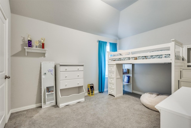 carpeted bedroom featuring lofted ceiling and baseboards