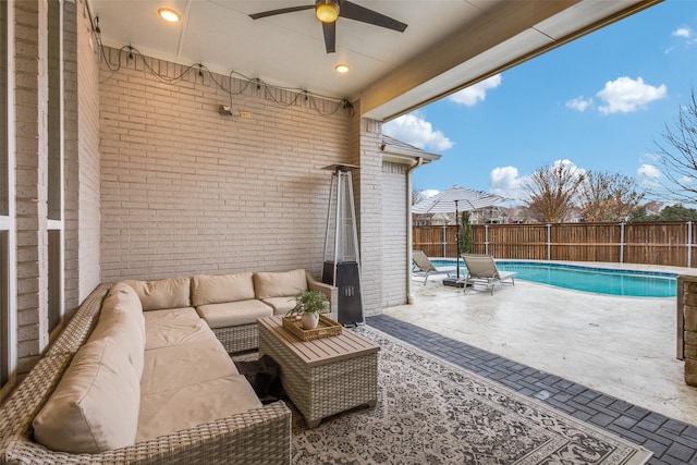 view of patio / terrace with an outdoor hangout area, a fenced backyard, a ceiling fan, and a fenced in pool