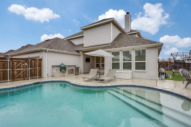 view of pool featuring a patio area, fence, a gate, and a fenced in pool