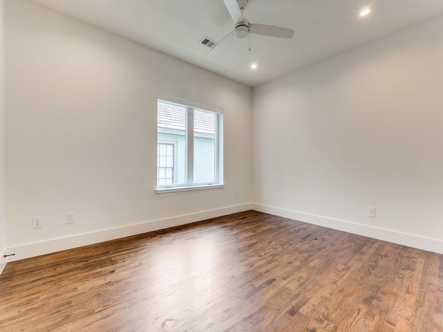 unfurnished room with visible vents, ceiling fan, baseboards, and wood finished floors