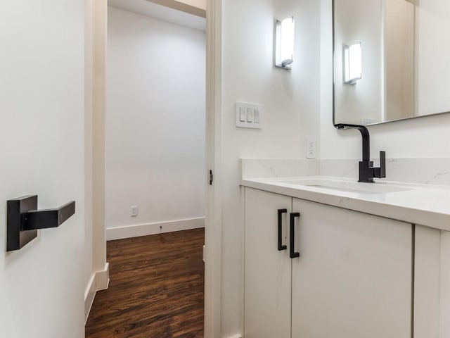 bathroom featuring baseboards, wood finished floors, and vanity