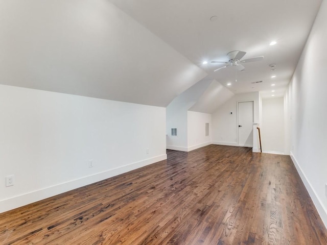 bonus room with lofted ceiling, dark wood-style flooring, visible vents, a ceiling fan, and baseboards