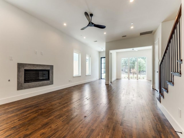 unfurnished living room with recessed lighting, a ceiling fan, a high end fireplace, wood finished floors, and baseboards