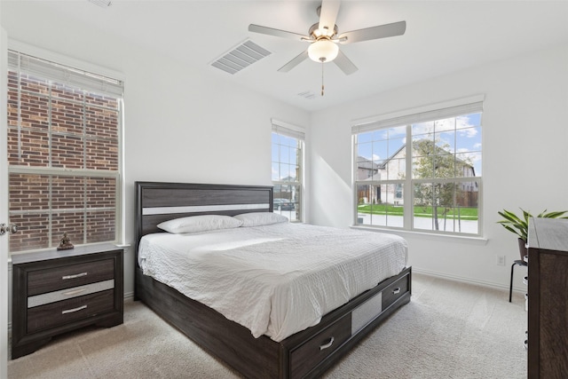 carpeted bedroom featuring baseboards, multiple windows, and visible vents