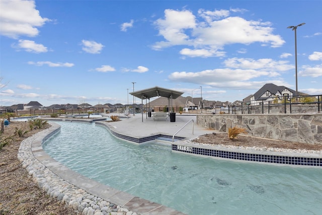 pool with a patio area and a residential view