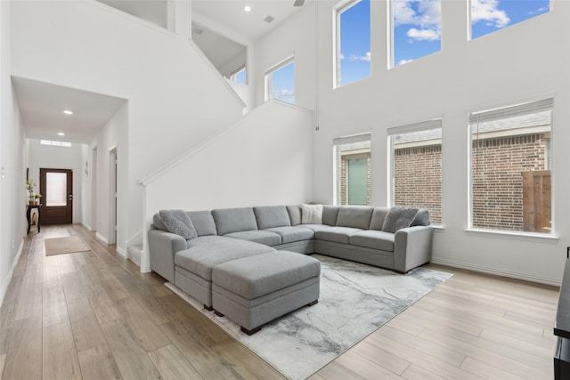 living room with light wood-type flooring, baseboards, and recessed lighting