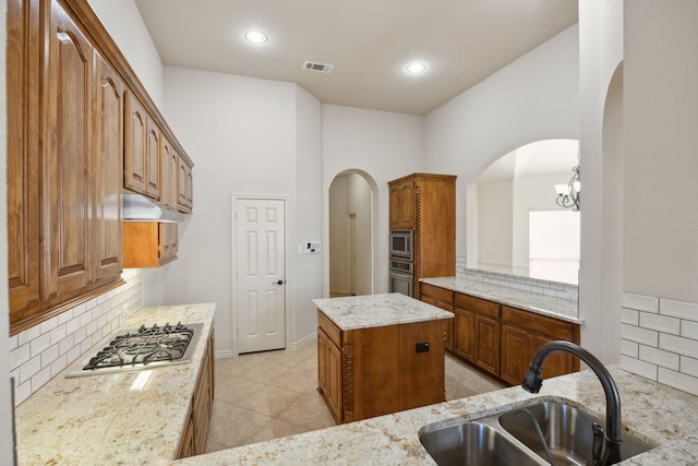 kitchen with light tile patterned floors, stainless steel appliances, a sink, visible vents, and backsplash