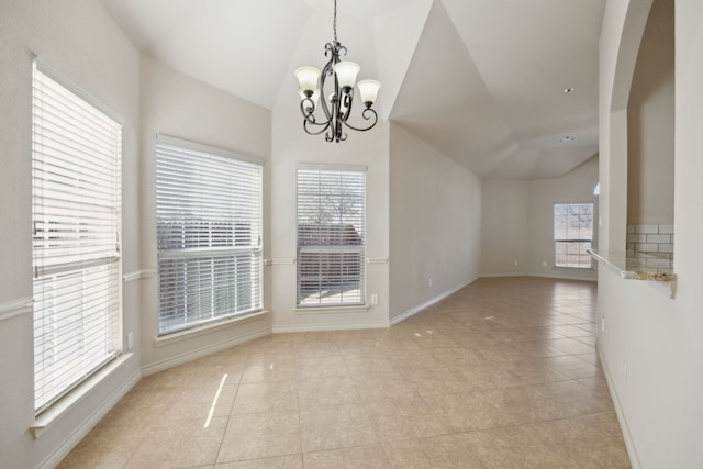 unfurnished dining area with lofted ceiling, light tile patterned floors, baseboards, and a chandelier