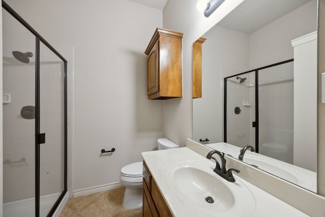 bathroom featuring toilet, a shower stall, vanity, tile patterned flooring, and baseboards