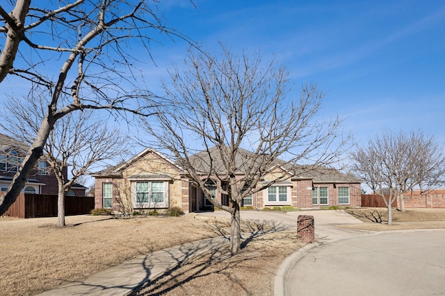 ranch-style home with brick siding and fence