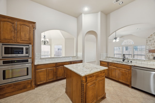 kitchen featuring appliances with stainless steel finishes, light tile patterned flooring, a sink, and backsplash