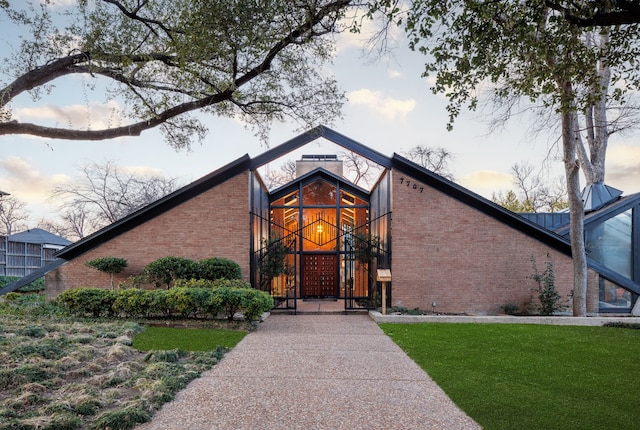 view of front facade featuring brick siding and a front lawn