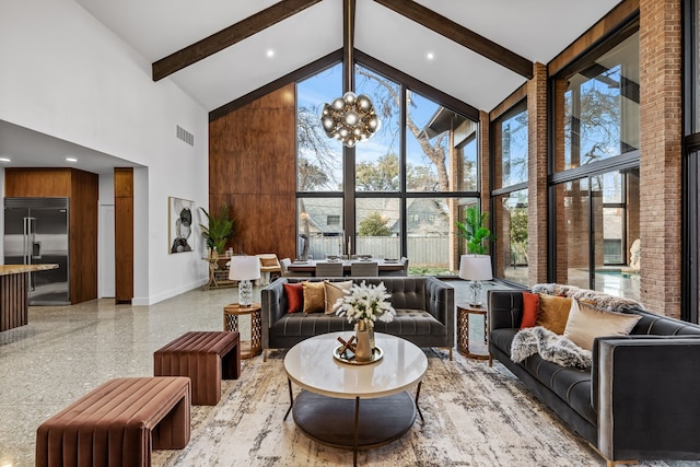 living area featuring baseboards, beamed ceiling, high vaulted ceiling, light speckled floor, and a notable chandelier