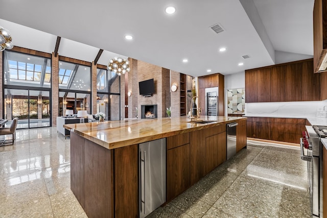 kitchen featuring recessed lighting, granite finish floor, a sink, high quality appliances, and open floor plan