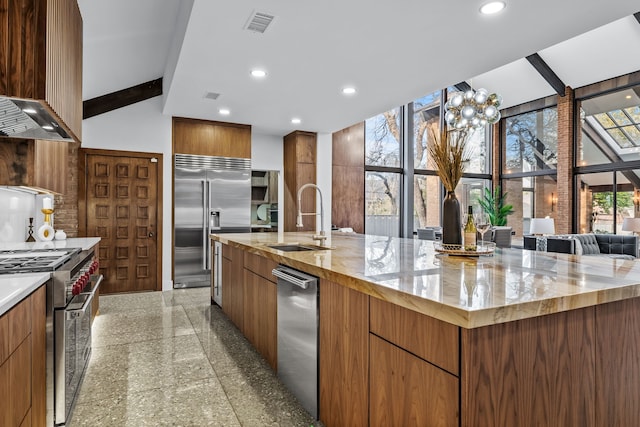 kitchen with high end appliances, modern cabinets, granite finish floor, a sink, and recessed lighting