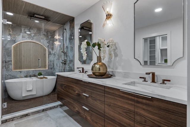 bathroom with a sink, a freestanding bath, a marble finish shower, and double vanity