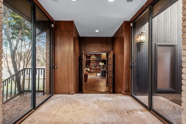 interior space with a wealth of natural light, visible vents, wooden walls, and recessed lighting