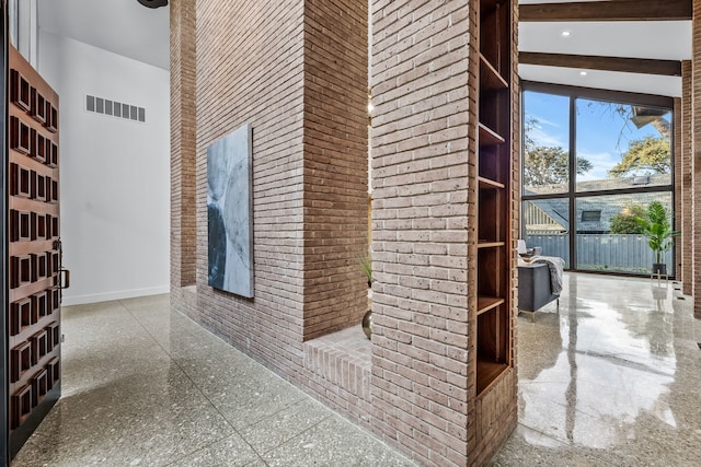 corridor with visible vents, baseboards, brick wall, beamed ceiling, and recessed lighting