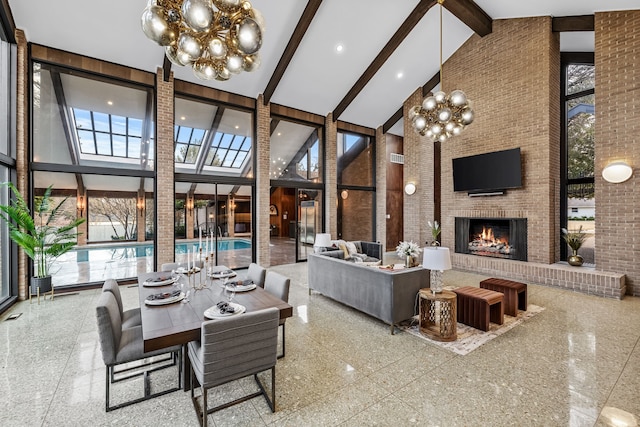 dining area featuring an outdoor brick fireplace, brick wall, a high ceiling, a healthy amount of sunlight, and granite finish floor