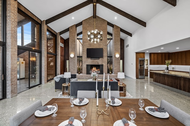 dining area featuring baseboards, beamed ceiling, granite finish floor, a fireplace, and high vaulted ceiling