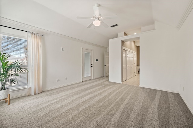 empty room featuring visible vents, light carpet, baseboards, and vaulted ceiling