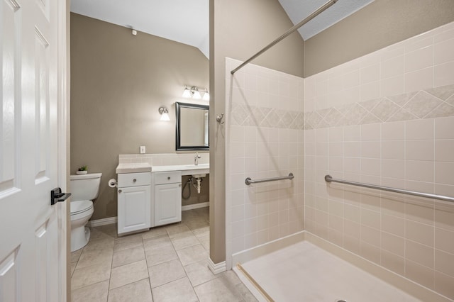 full bathroom featuring tile patterned flooring, toilet, vaulted ceiling, a tile shower, and vanity